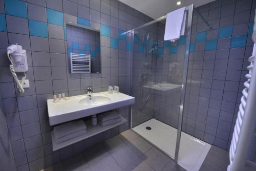 a bathroom with a sink and a shower at Hotel Val Vert in Pouilly-en-Auxois