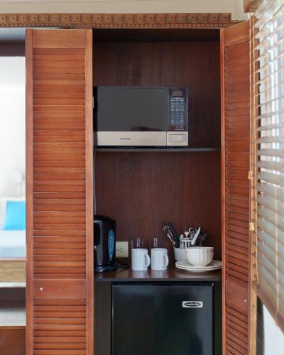 a kitchen with a microwave and a refrigerator at Arubiana Inn Hotel in Palm-Eagle Beach