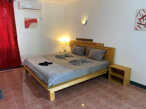 ein Schlafzimmer mit einem Bett in einem Zimmer mit einer Lampe in der Unterkunft Le Pôle in Grand Baie