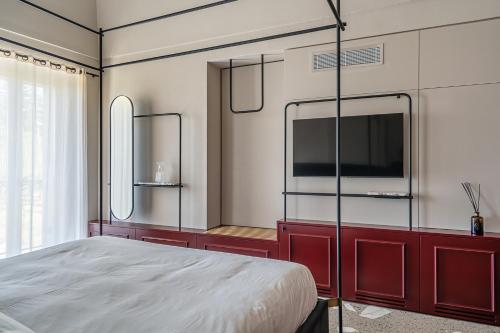 a bedroom with a bed and a flat screen tv at Laqua Countryside in Vico Equense