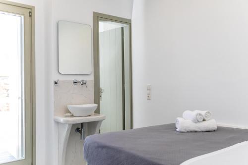 um quarto branco com uma cama e um lavatório em Depis castle Renata luxury apartments em Naxos Chora