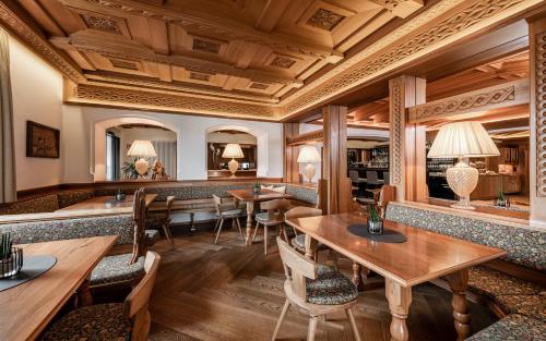 カステルロットにあるHotel Villa Kastelruthの木製の天井、テーブルと椅子のあるレストラン