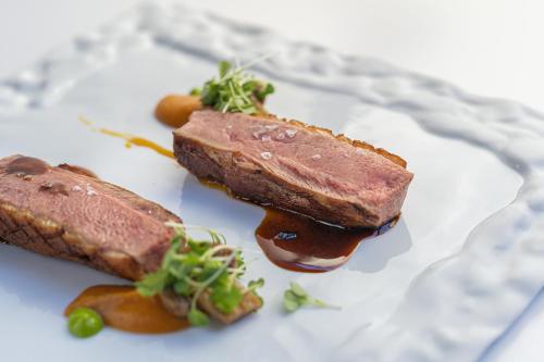 two pieces of meat on a white plate with sauce at Laqua Countryside in Vico Equense
