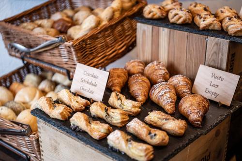 un assortiment de différents types de pains et de pâtisseries dans l'établissement Hotel Cavallino D'Oro Bed&Breakfast, à Castelrotto