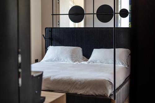 a bed with a black head board and white pillows at Laqua Countryside in Vico Equense