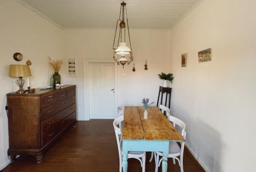 a dining room with a wooden table and white chairs at Dolce Vivere by Konnect, Gaios Paxos in Gaios
