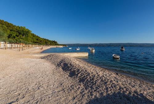 a beach with boats in a body of water at Tourist Settlement Brzet in Omiš