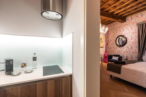 a kitchen and a bedroom with a bed in a room at Kairos by Florence Art Apartments in Florence
