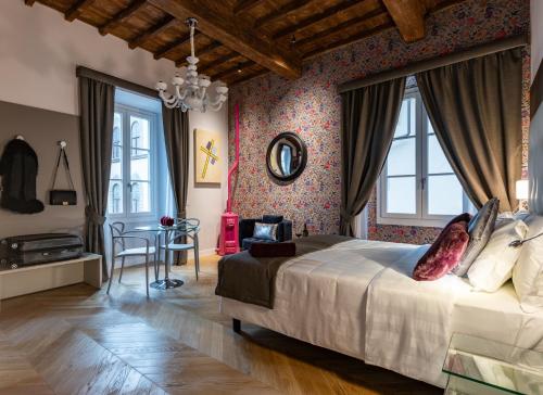 a bedroom with a large bed and a table at Kairos by Florence Art Apartments in Florence