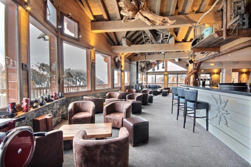 - un bar avec des chaises et des tables en cuir dans une pièce dans l'établissement Chalet Carte Blanche Hugo, à Belle Plagne