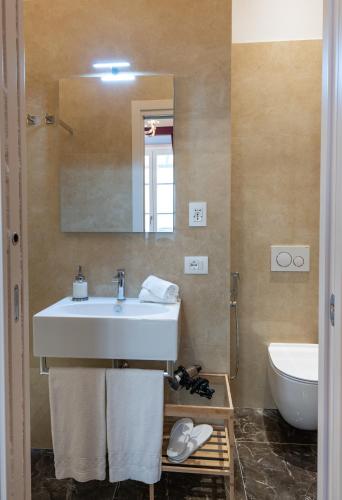 a bathroom with a sink and a toilet and a mirror at Kairos by Florence Art Apartments in Florence