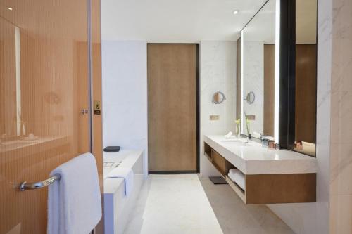 a bathroom with two sinks and a large mirror at Crowne Plaza Hangzhou Qiantang - The subway can reach the West Lake scenic area as well as the airport and high-speed rail station, adjacent to Jinsha Lake and Longfor paradise walk in Hangzhou
