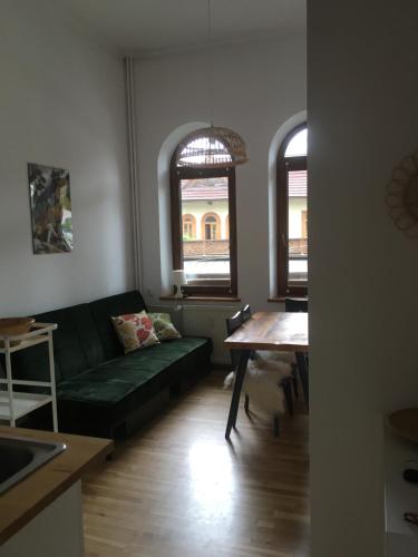 a living room with a green couch and a table at Blisko miło ładnie Apartament w centrum Zakopanego in Zakopane