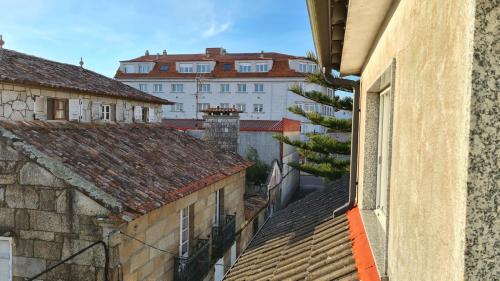 vistas a una ciudad con edificios y tejados en pension mar de rosa, en Villanueva de Arosa