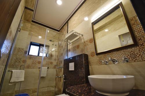 a bathroom with a sink and a shower with a mirror at Umaid Residency - A Regal Heritage Home in Jaipur