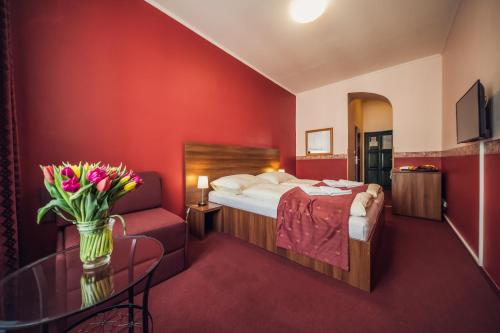 Cette chambre comprend un lit et une table fleurie. dans l'établissement Hotel Czechia, à Prague
