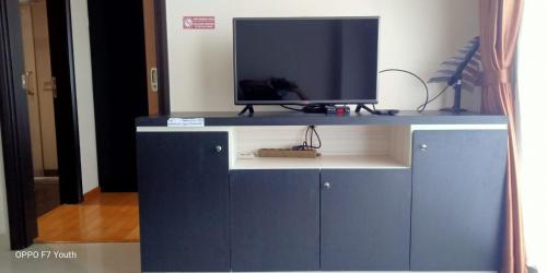 ein Fernseher auf einem blauen Schrank in der Unterkunft MG Suites 1 Bedroom Apartment Sea View Semarang (KUMU SUITES) in Semarang