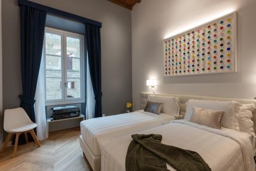 a bedroom with two beds and a painting on the wall at Kairos by Florence Art Apartments in Florence
