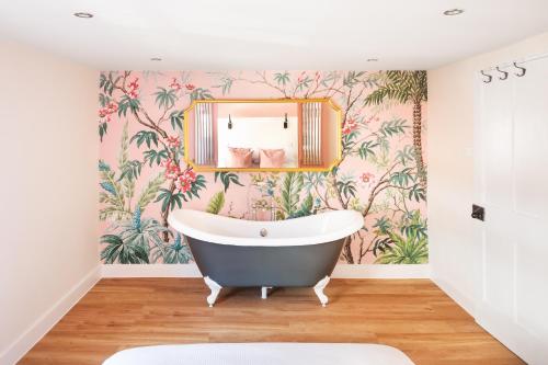 a bathroom with a bath tub and floral wallpaper at Worthing town house in Worthing