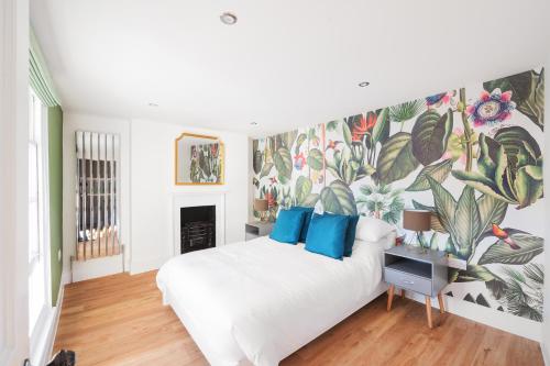 a bedroom with a large white bed with a floral wallpaper at Worthing town house in Worthing