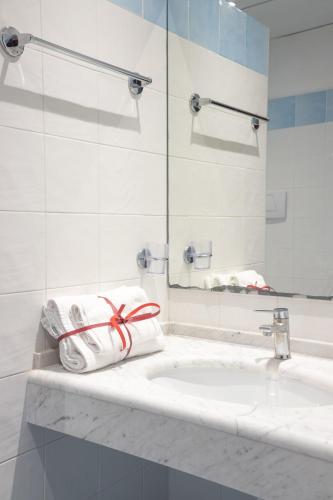 a white bathroom with a sink and a mirror at Hotel Consul - Family Hotel in Riccione