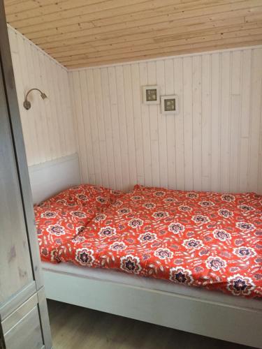 1 cama con edredón rojo en una habitación en Ferienhaus Stolley, en Silberstedt