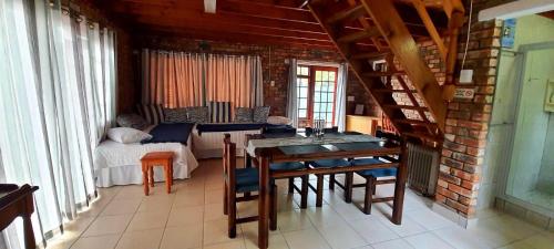 a room with a table and chairs and a bedroom at Cozy Cottage +/- 500m from the beach in Cape Town