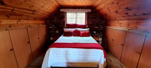 a bedroom with a bed in a wooden cabin at Cozy Cottage +/- 500m from the beach in Cape Town