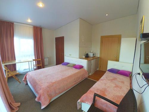 ein Hotelzimmer mit 2 Betten mit lila Kissen in der Unterkunft Guest house V gostyakh kak doma in Kasan