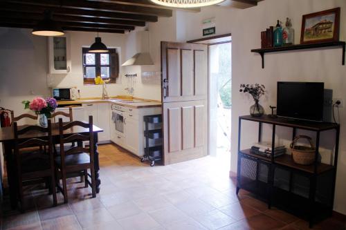 a kitchen with a table and a dining room at El Molín de La Vega Agroturismo in Ribadesella