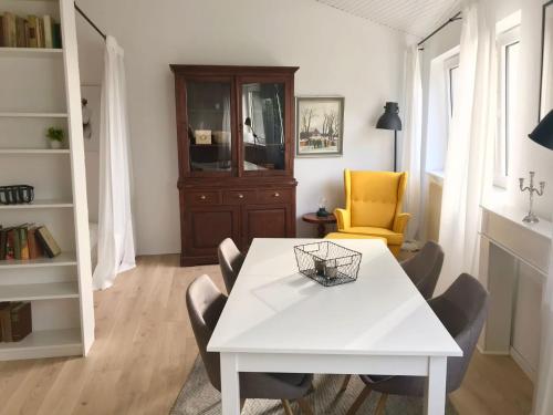 a dining room with a white table and chairs at Gemütliches Bergappartement mit Weitblick in Bad Bentheim