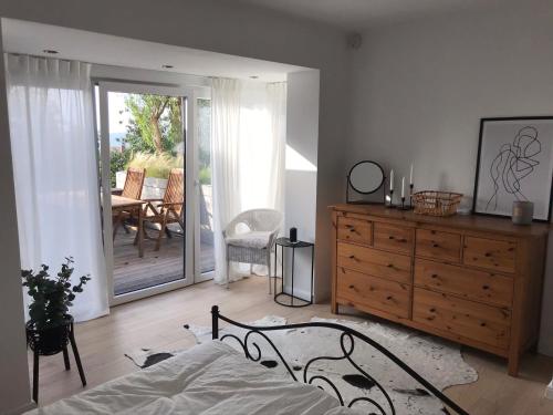 - une chambre avec un lit, une commode et une terrasse dans l'établissement Gemütliches Bergappartement mit Weitblick, à Bad Bentheim