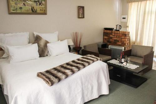 1 dormitorio con 1 cama blanca grande y sala de estar en Mountain View Hotel - Lesotho en Leribe