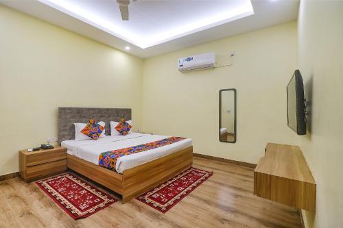 a bedroom with a bed and a television in it at FabExpress Le Gardenia in Patna