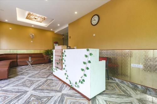 a lobby with a door with a clock on the wall at FabExpress Le Gardenia in Patna