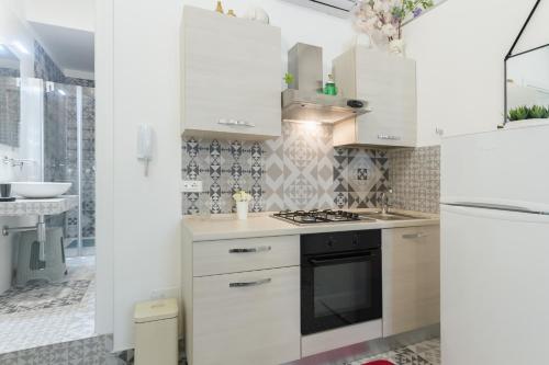 a kitchen with white cabinets and a stove top oven at Maison Rudy - by Annet in Lecce