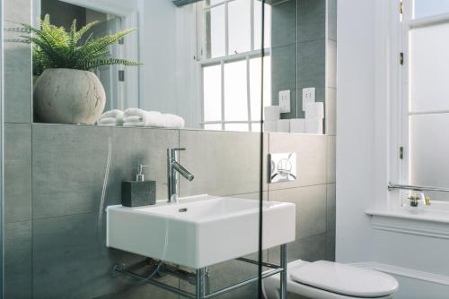 een badkamer met een witte wastafel en een toilet bij ALTIDO Bold and Spacious 1bed home, near Haymarket train station in Edinburgh