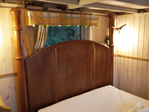 a wooden bed in a room with a window at Cabin Dan in Great Malvern
