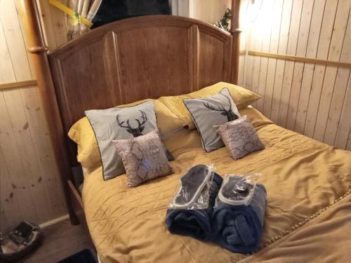 a bed with shoes and pillows on it at Cabin Dan in Great Malvern