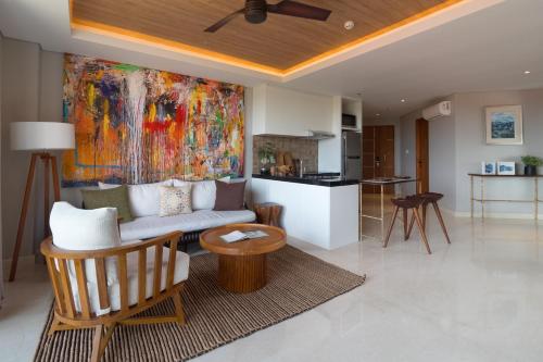 a living room with a couch and a kitchen at Beachwalk Residence in Kuta