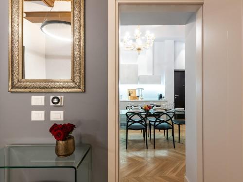 a dining room with a mirror and a table with chairs at Kairos by Florence Art Apartments in Florence