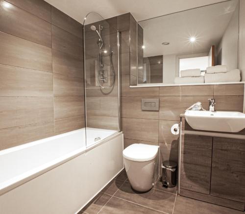 een badkamer met een bad, een toilet en een wastafel bij Birmingham Central By Charles Hope in Birmingham