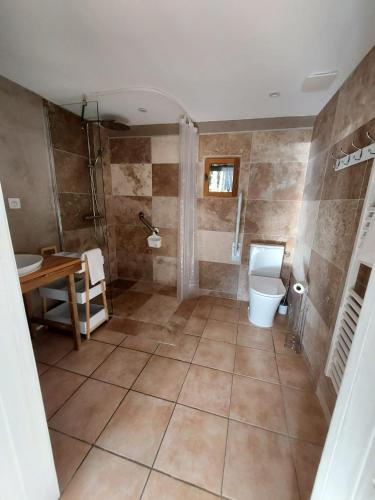 La salle de bains est pourvue de toilettes, d'un lavabo et d'une table. dans l'établissement Les Gîtes du Grand Chêne, à Saint-Paul-en-Born