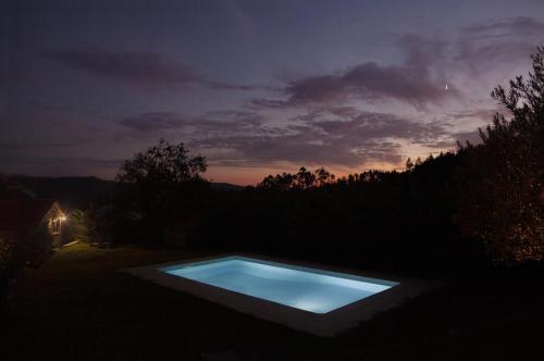 a swimming pool in a yard at night at Casas d'Oliva in Caramulo
