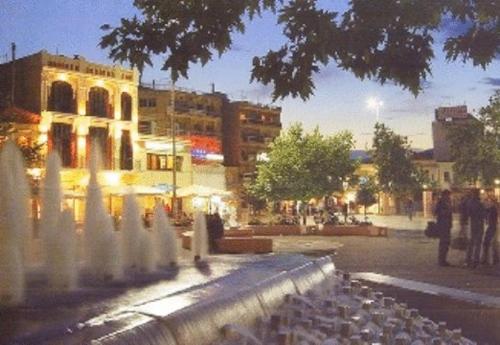 a group of pigeons standing around a fountain in a city at Astoria Hotel Traditional in Komotini