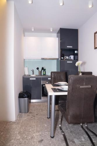 a kitchen with a table and chairs in a room at Mariahilf Suites in Vienna