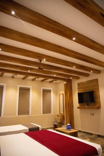 a bedroom with a bed and a flat screen tv at Hotel Ganesh Palace in Rāmeswaram