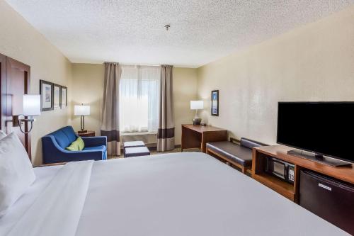 a hotel room with a large bed and a flat screen tv at Comfort Inn Charleston South in Charleston