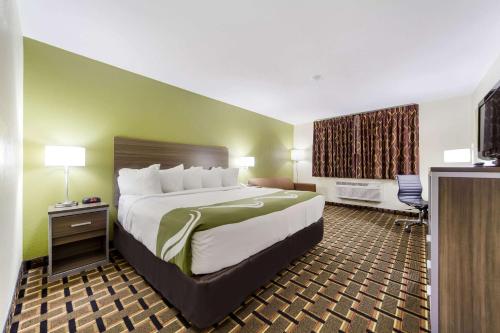 a hotel room with a large bed and a desk at Quality Inn Lincoln Cornhusker in Lincoln