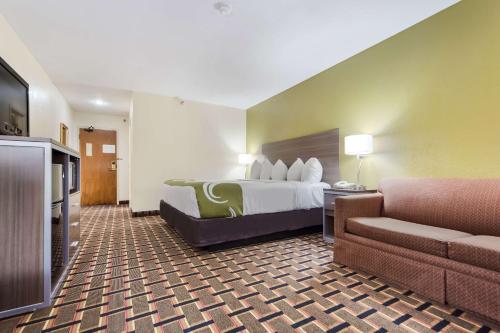 a hotel room with a bed and a couch at Quality Inn Lincoln Cornhusker in Lincoln